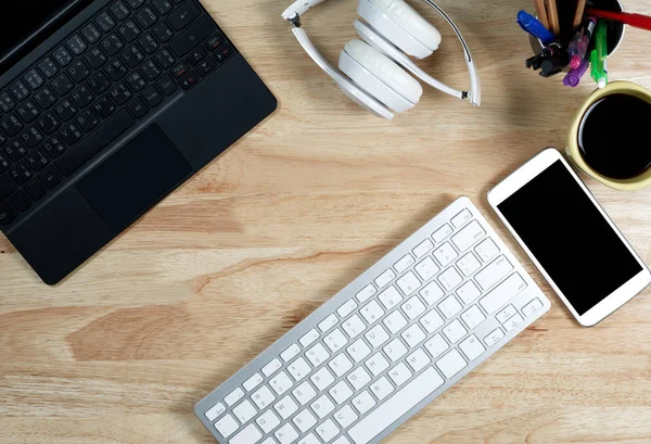 Beyaz kulaklık ve ahşap masa üzerinde ahşap masa üstünde klavye. kavramı için dijital müzik dinle. Vintage tarzı