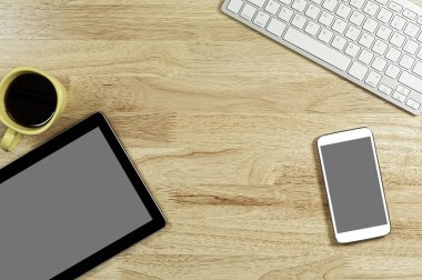 boş ekran akıllı telefonlar ve tablet Pc bilgisayar klavye ve bir fincan kahve kompozisyon kopya alanı metni ile ahşap Masaüstü