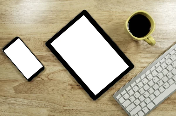 空白の画面のスマート フォンやタブレット コンピューターのキーボードとテキストのコピー スペースと組成でのコーヒーのカップと木製のデスクトップ上 — ストック写真