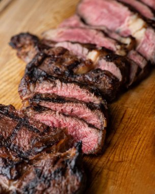 Kesme tahtasının üzerinde orta pişmiş biftek.