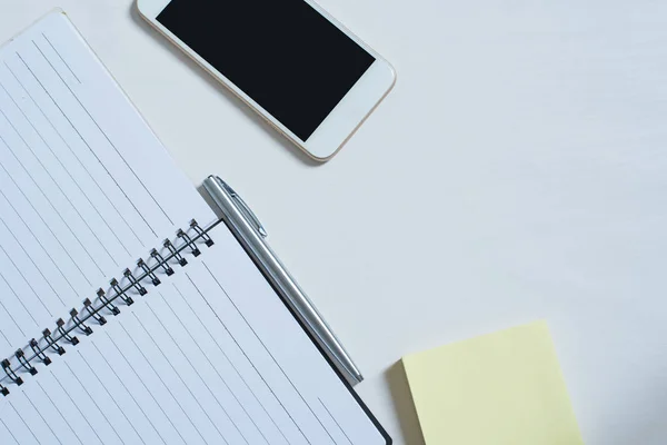 Cep telefonu, açık kitap, kalem, papernote Üstten Görünüm