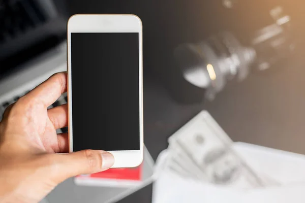 Sol el üzerinde bulanıklık blackground dizüstü bilgisayar ile akıllı telefon tutarak