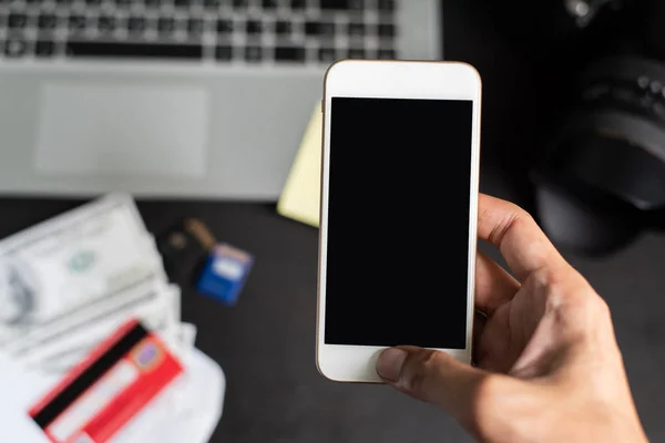 Sağ el smartphone üzerinde bulanıklık blackground dizüstü bilgisayar, d ile tutarak