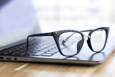 Laptop klavye ahşap masa, gözlük yakın çekim