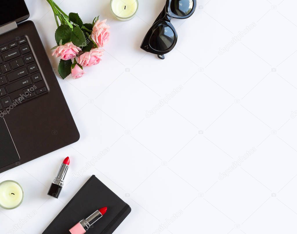 Flatlay of fashion womens office desk with laptop, pink roses flowers, cosmetics, accessories on white background.