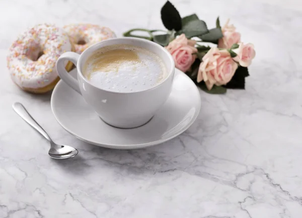 Café con rosquilla colorida en fondo de mármol blanco . — Foto de Stock