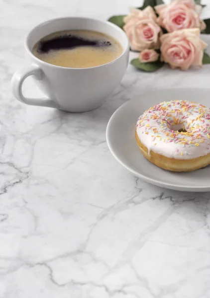 Café con rosquilla colorida en fondo de mármol blanco . — Foto de Stock