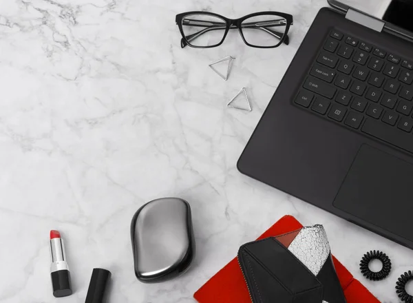 Espacio de trabajo plano con ordenador portátil, planificador, gafas, teléfono móvil, aros, corbata de pelo, peine y lápiz labial . —  Fotos de Stock