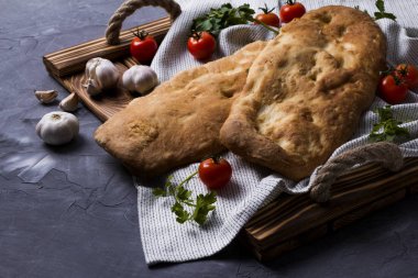 Domates, sarımsak ve maydanoz ile ahşap tepsi üzerinde lezzetli taze tandır ekmek. Ulusal Gürcü mutfağı ve yemekleri.