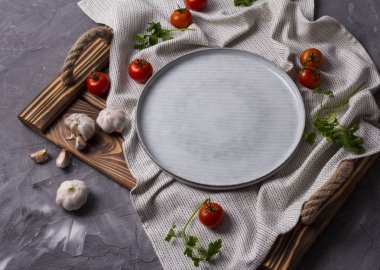 Çiftçiler domates, sarımsak ve maydanoz gri arka planda bir tepsi üzerinde Boş plaka