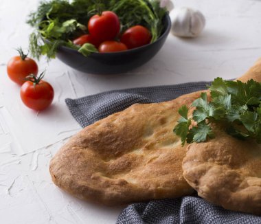 Mutfak havlusu veya peçete üzerine domates, sarımsak ve maydanoz ile tandır ekmeği.
