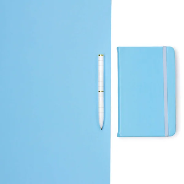 Flat lay of woman desk with notepad and pen on blue paper backgr — Stock Photo, Image