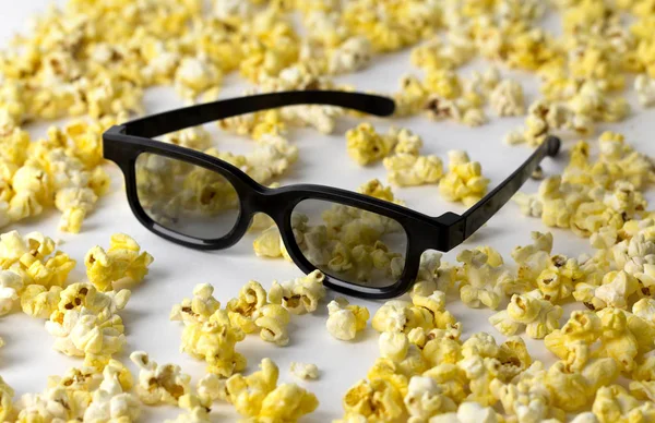 Popcorn i okulary 3D w białym stole. — Zdjęcie stockowe