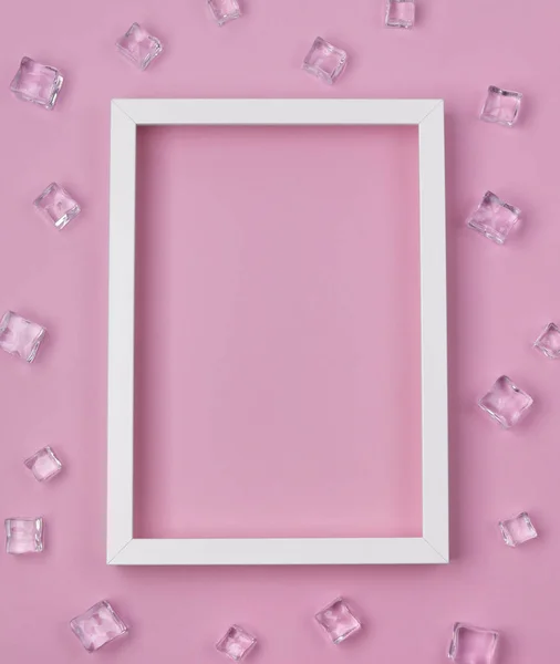 Плоский макет з білою рамкою та кубиками льоду на рожевому фоні . — стокове фото