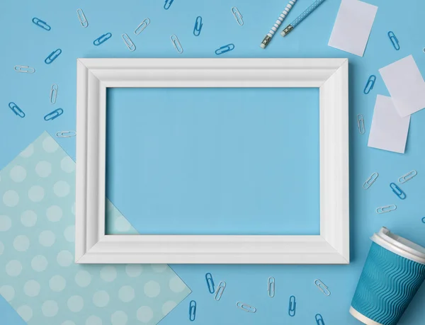 Flat lay empty frame and office supplies on blue pastel background — Stock Photo, Image