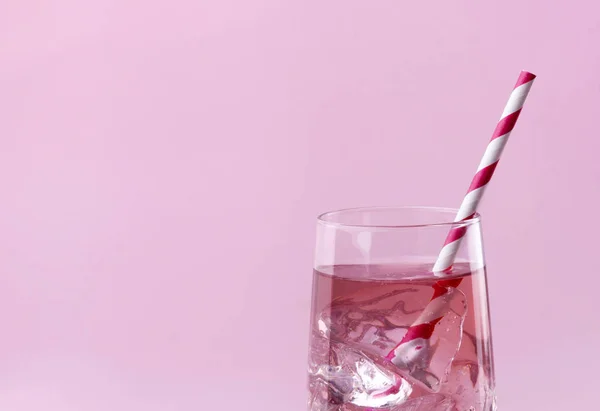 Růžový koktejl na růžovém pozadí s proužkované růžovou slámou. — Stock fotografie