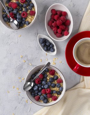 Düz yatıyordu kahve, beton arka plan üzerinde yaban mersini ve ahududu ile yulaf gevreği kase.