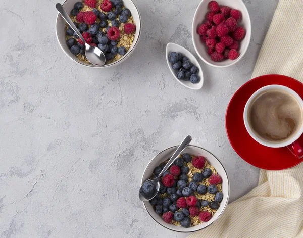 Düz yatıyordu kahve, beton arka plan üzerinde yaban mersini ve ahududu ile yulaf gevreği kase.