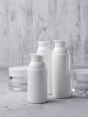 Gri arka planda kozmetik krem şişe seti.