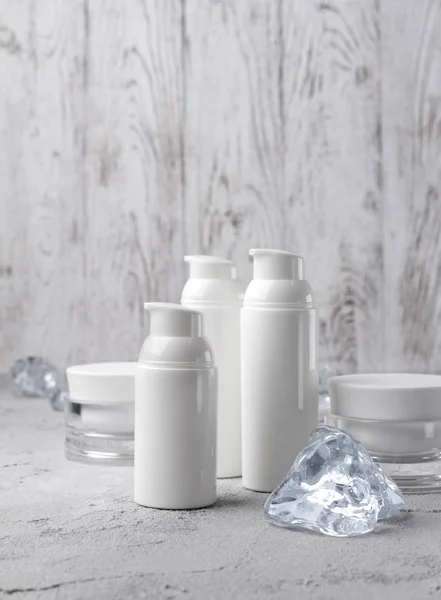 Sada kosmetických Smetanových lahví s ledem na šedý stůl — Stock fotografie