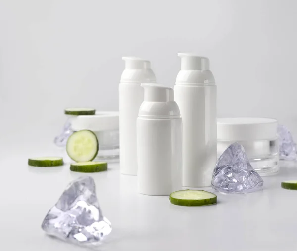 Sada kosmetických Smetanových lahví s okurku a ledem na bílém BAC — Stock fotografie