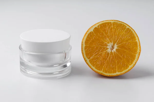 Frasco de creme cosmético com laranja sobre fundo branco . — Fotografia de Stock