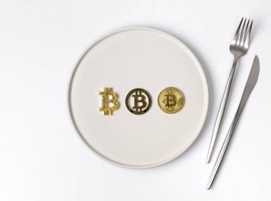 Beyaz boş tabakta üç altın bitcoin servis