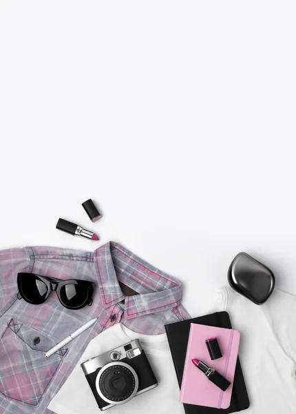 Kvinnors t-shirt, Snickers, solglasögon, kamera, anteckningsblock och läppstift. — Stockfoto