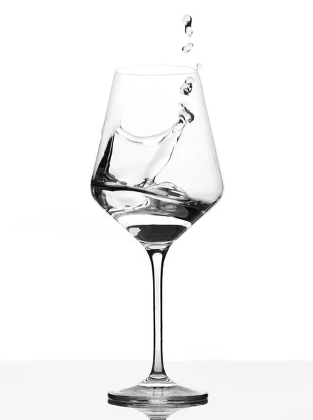 Clear Wineglass com explosão de água. Movimento contra o branco — Fotografia de Stock