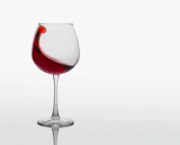 Copo de vinho tinto com salpicos no fundo branco . — Fotografia de Stock