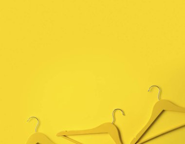 Yaratıcı düz kopya alanı ile sarı arka planda ahşap askıları yatıyordu.