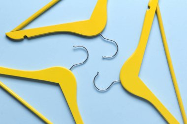 Minimalist üst görünüm düz mavi arka planda sarı ahşap askıları yatıyordu.