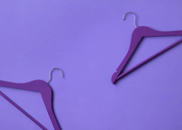 创意平面铺设紫色木制衣架在紫色背景与复制空间. — 图库照片