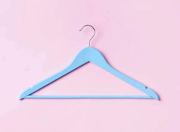 Top view flat lay single blue wooden hanger pink pastel background. — Stock Photo, Image