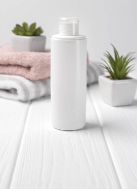 Ahşap masa üzerinde otlar ve havlu ile Kozmetik şişe kapları.