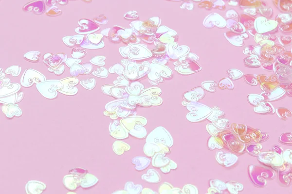 El confeti holográfico del corazón brilla sobre fondo rosa — Foto de Stock