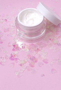 Pembe holografik kalp konfeti kozmetik krem losyon kavanoz kopya alanı ile arka plan Parıldıyor.