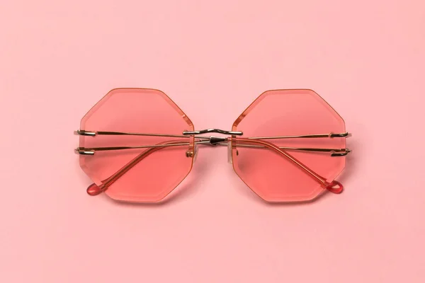 Креативные коралловые трикотажные солнцезащитные очки на розовом фоне. — стоковое фото
