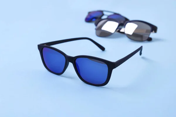 Varias gafas de sol con estilo sobre fondo creativo azul —  Fotos de Stock