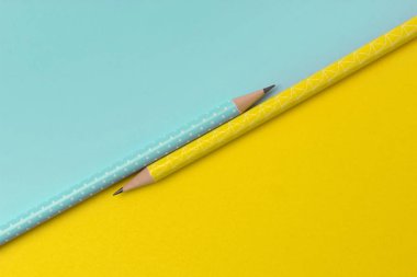 Renkli yaratıcı kağıt arkaplanda turkuaz ve sarı kalemlerin üst görünümü
