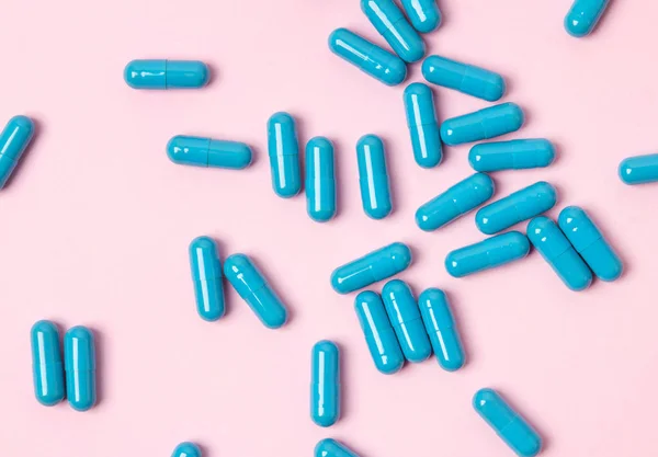 Μπλε χάπια σε ροζ φόντο. Επίπεδη θέα στην κορυφή. — Φωτογραφία Αρχείου