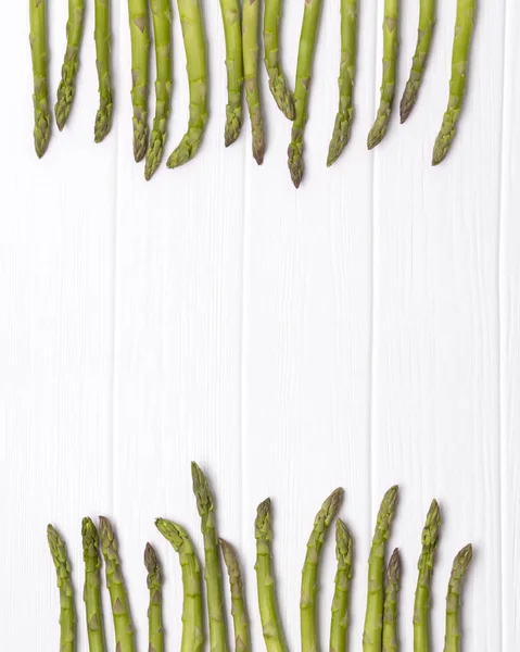 Bouquet d'asperges vertes fraîches sur fond de table en bois blanc . — Photo