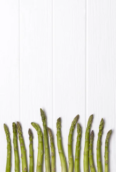 Bunch of fresh green asparagus on white wooden table background. — Stock Photo, Image
