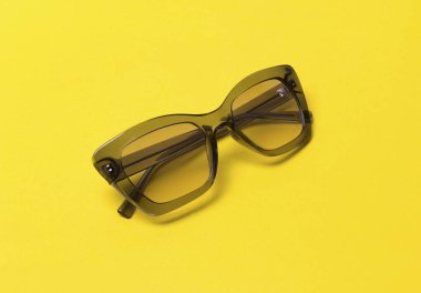 Sarı arka plan üzerinde gri modern moda güneş gözlüğü.