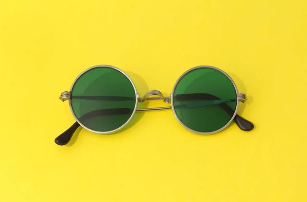 Vintage fashionable round green sunglasses on yellow background — Stock Photo, Image