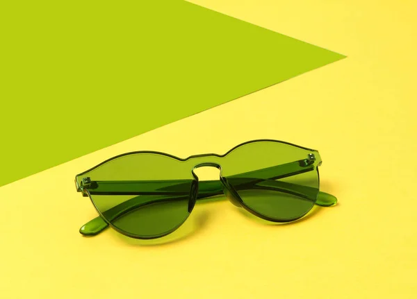 창조적 인 노란색 배경에 현대 유행 녹색 선글라스 — 스톡 사진