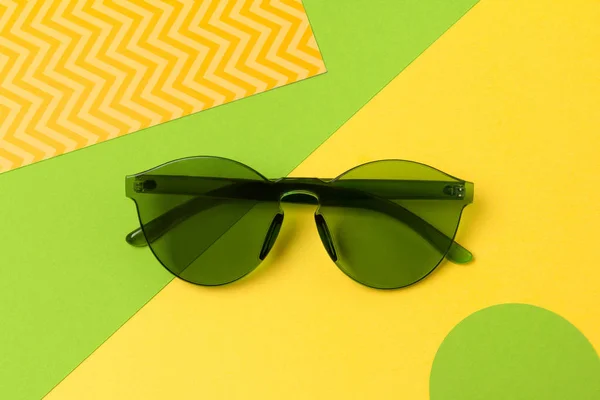 Gafas de sol verdes de moda modernas sobre fondo amarillo creativo —  Fotos de Stock