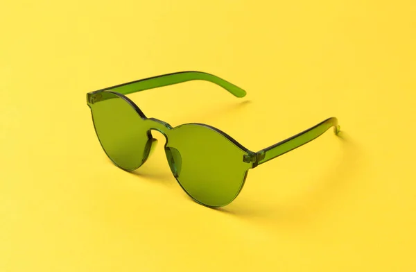 노란색 배경에 녹색 현대 유행 선글라스 — 스톡 사진