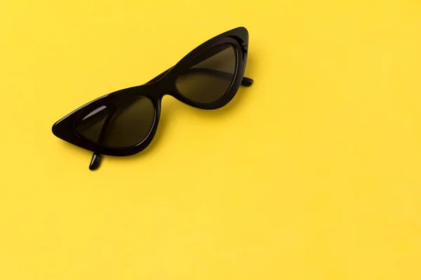 Czarne nowoczesne modne okulary przeciwsłoneczne na żółtym tle. — Zdjęcie stockowe