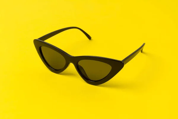 Black modern fashionable sunglasses on yellow background. — Stock Photo, Image